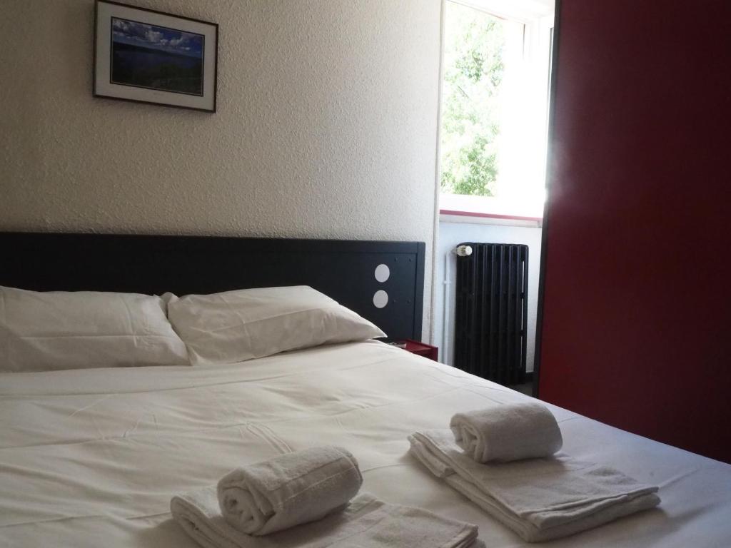 Rúm í herbergi á HOTEL LE FOIRAIL