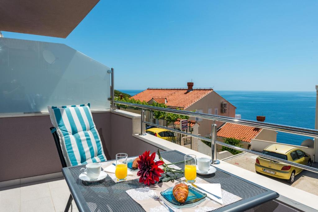 una mesa con un plato de comida en el balcón en Apartment Tonka, en Cavtat