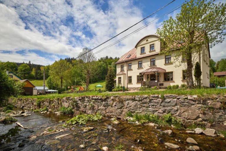 a house with a stone wall next to a river at BOUDA MORAVA in Dolni Dvur