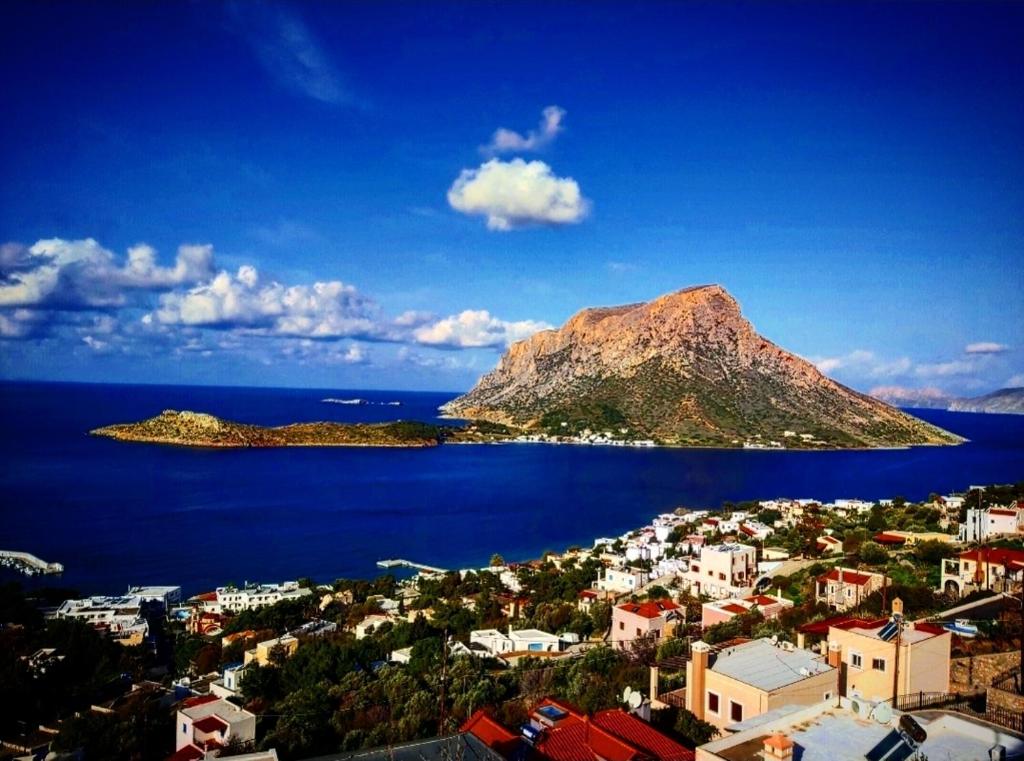 a view of a city and a mountain in the water at Elsa's house in Kalymnos