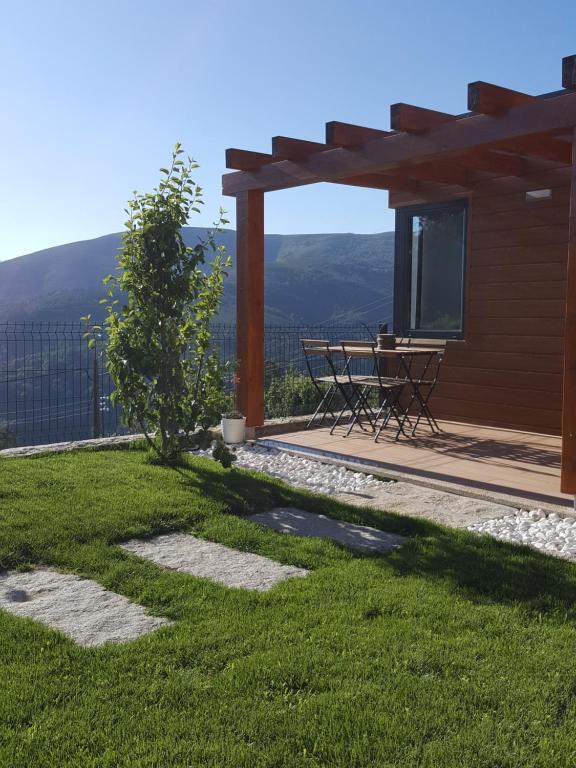 un patio con mesa y vistas a las montañas en Chalet Pôr do Sol, en Castro Daire