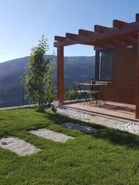 a patio with a table and a view of the mountains at Chalet Pôr do Sol in Castro Daire
