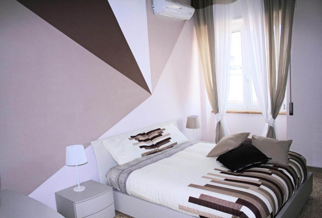 a bedroom with a bed with a geometric wall at Casa di Giulia in Caserta
