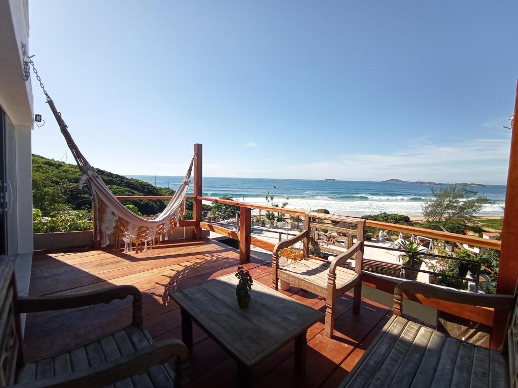balcón con hamaca y vistas a la playa en Lofts do Morro Magico en Búzios