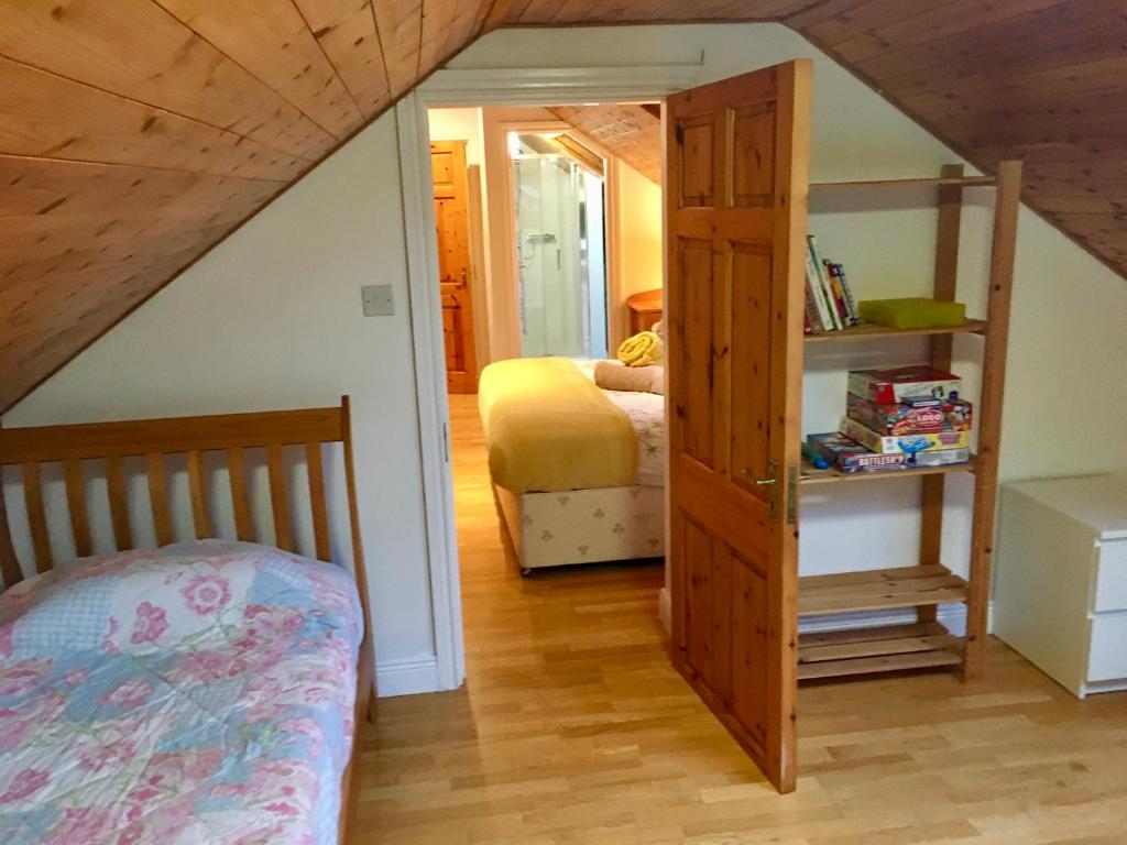 a bedroom with a bed and a book shelf next to a bedroom at Rugged Glen Accommodation in Glengarriff