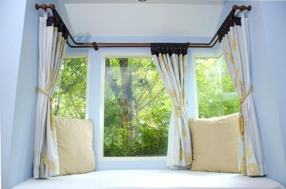 a window with curtains and pillows in a room at Baanmontra Beach Resort - Bankrut in Ban Krut