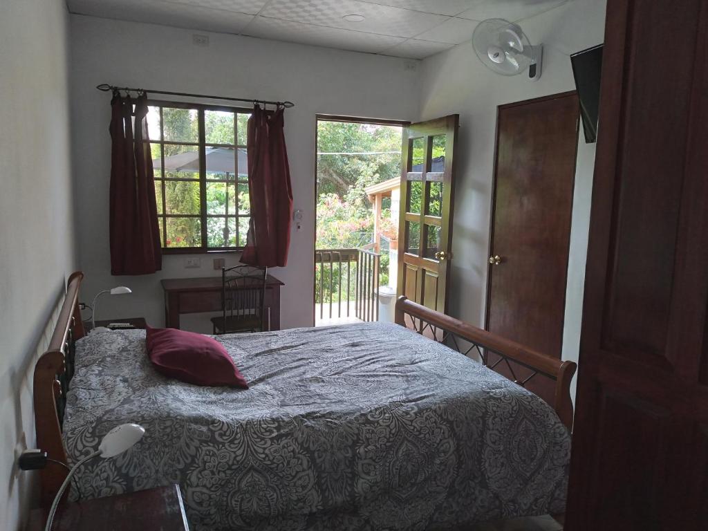 een slaapkamer met een bed, een raam en een deur bij Aparthotel Boquete Apartments in Boquete