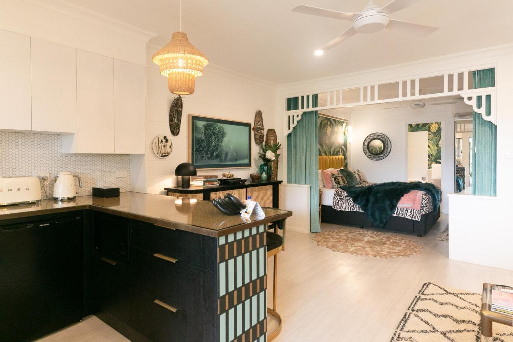 a kitchen and living room with a bed in the background at NOMAD - Luxe apartment in Port Douglas