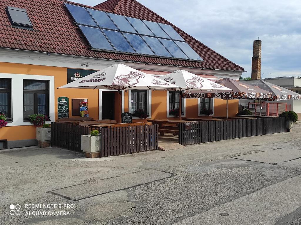 um restaurante com mesas e guarda-sóis fora dele em Ubytování Jeřábek em Lasenitz