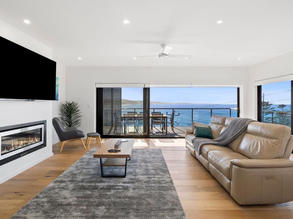a living room with a couch and a fireplace at Oceania 1 in Lorne