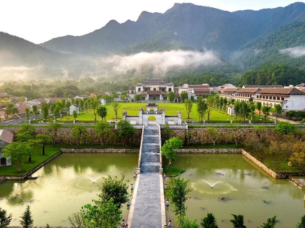 a view of a town with a lake and mountains at Làng Nương Yên Tử (Yên Tử Village) in Uông Bí