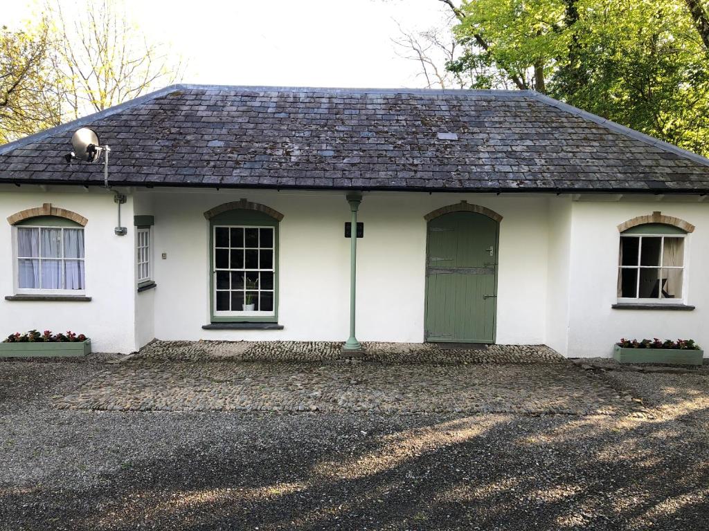 a white house with a green door and windows at Stables Cottage, Idyllic Location Stunning Views in Llandysul
