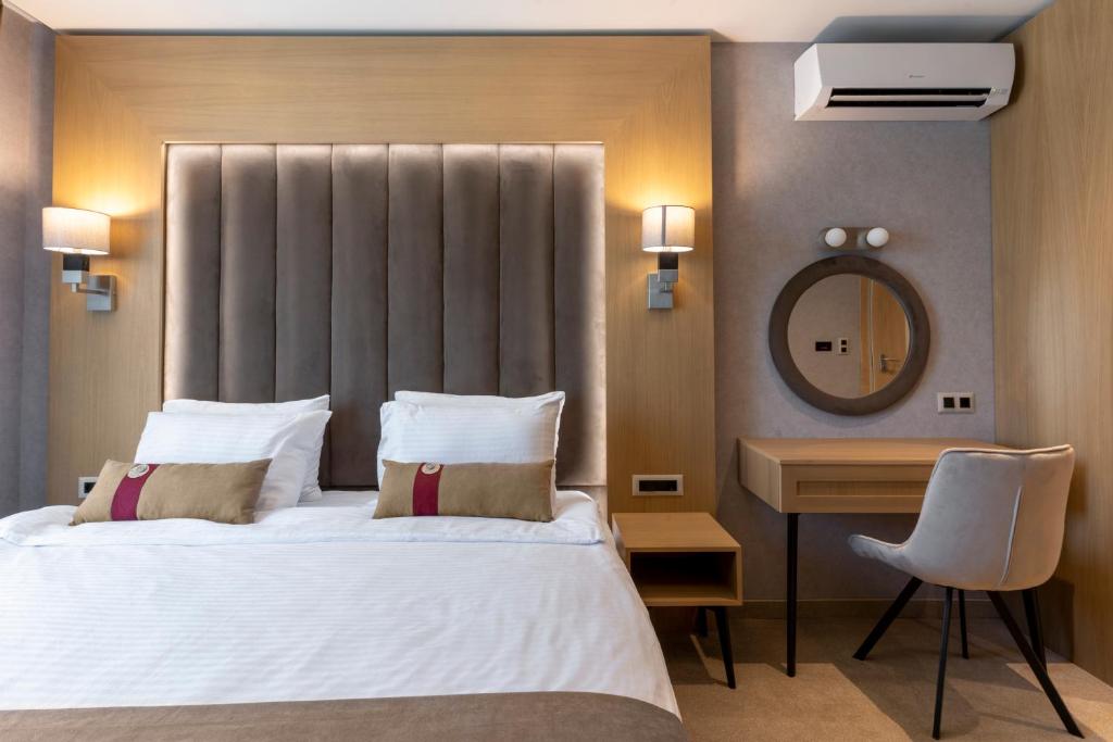 プロブディフにあるCity Park Innのベッドと机と鏡のある寝室