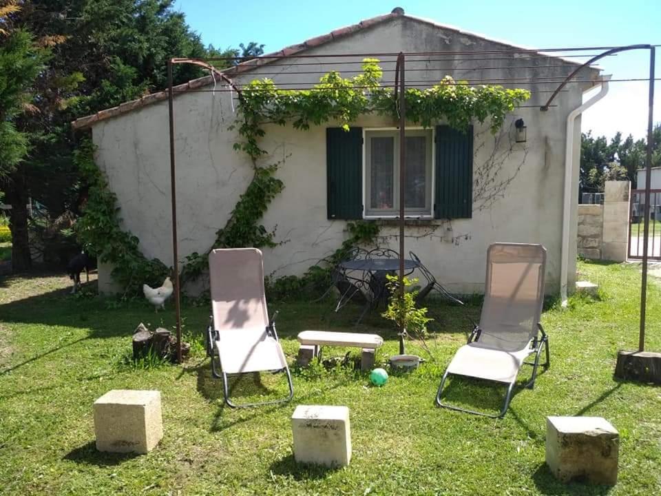 dos sillas y una mesa en el patio de una casa en Atelier Benjaminte, en Maillane