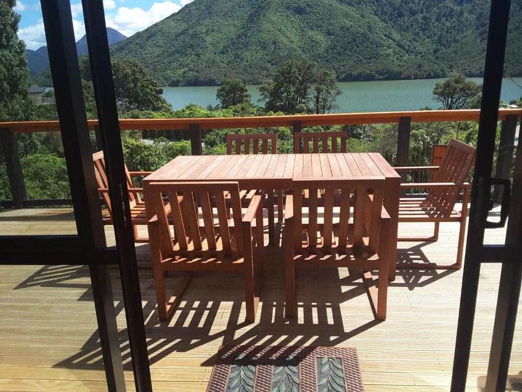 a wooden table on a deck with a view of a lake at Marlborough Sounds Accommodation 792 in Havelock