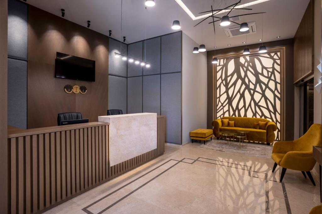 a lobby with a reception desk and a yellow couch at City Park Inn in Plovdiv
