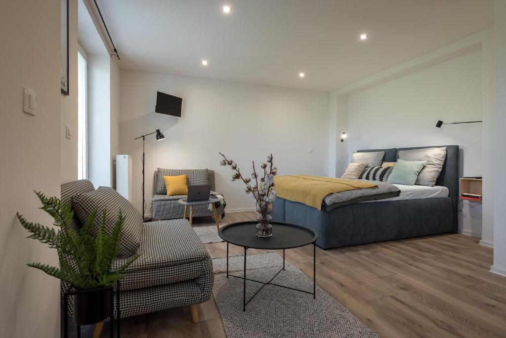 Symple apartments في كوشيتسه: غرفة معيشة مع سرير وأريكة