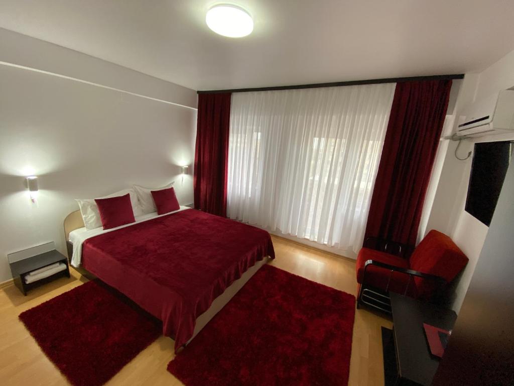 a bedroom with a red bed and a red chair at Oriana in Constanţa