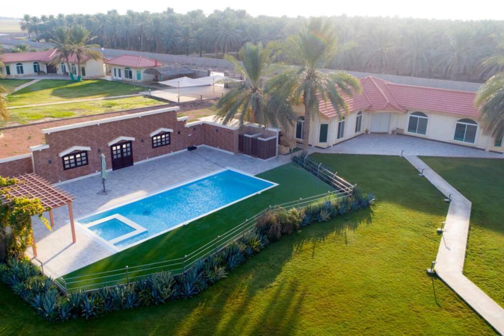 uma vista aérea de uma casa com piscina em مزرعة ومنتجع (منتجع غضي) em Aḑ Ḑalfa‘ah