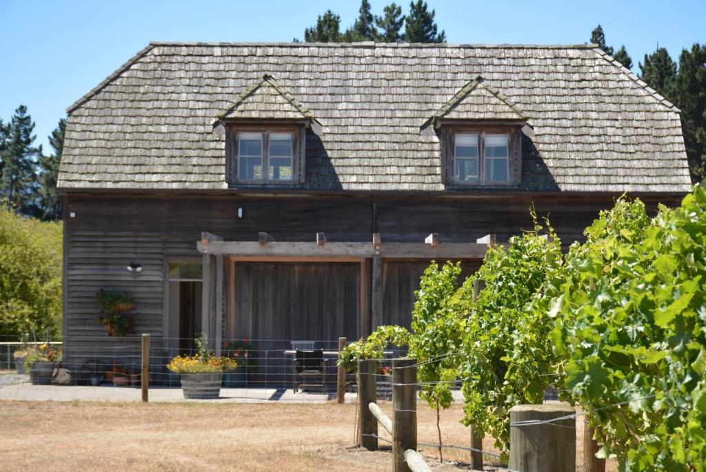 un granero de madera con dos ventanas en la parte superior en DDOG Vineyard & BnB, en Renwick