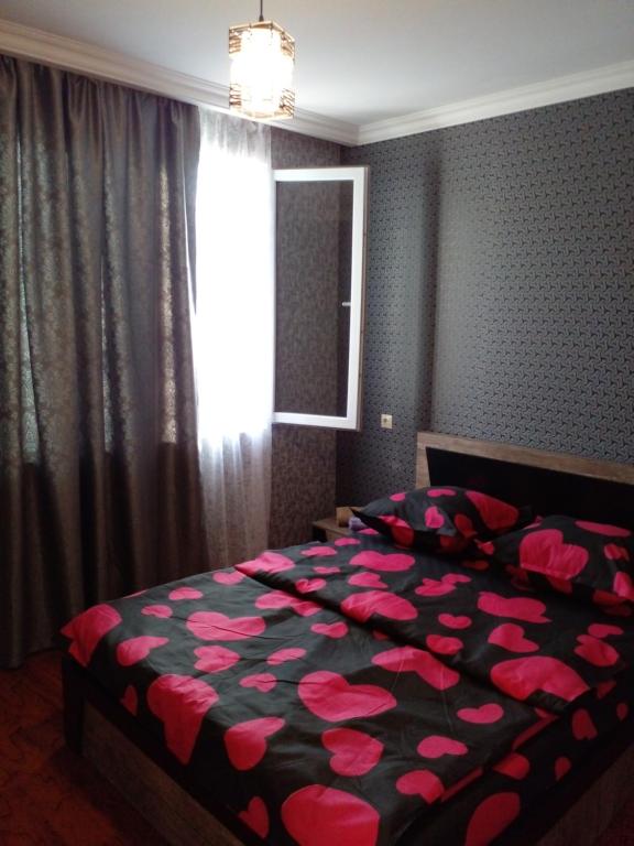 a bedroom with a bed with pink flowers on it at Pirosmani 66 in Sighnaghi