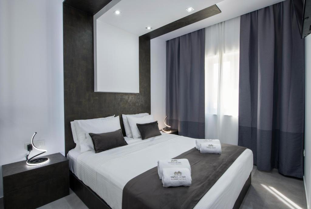 una camera da letto con un grande letto bianco e una finestra di TWIN'S HOME LUXURY SUITES a Alikianós