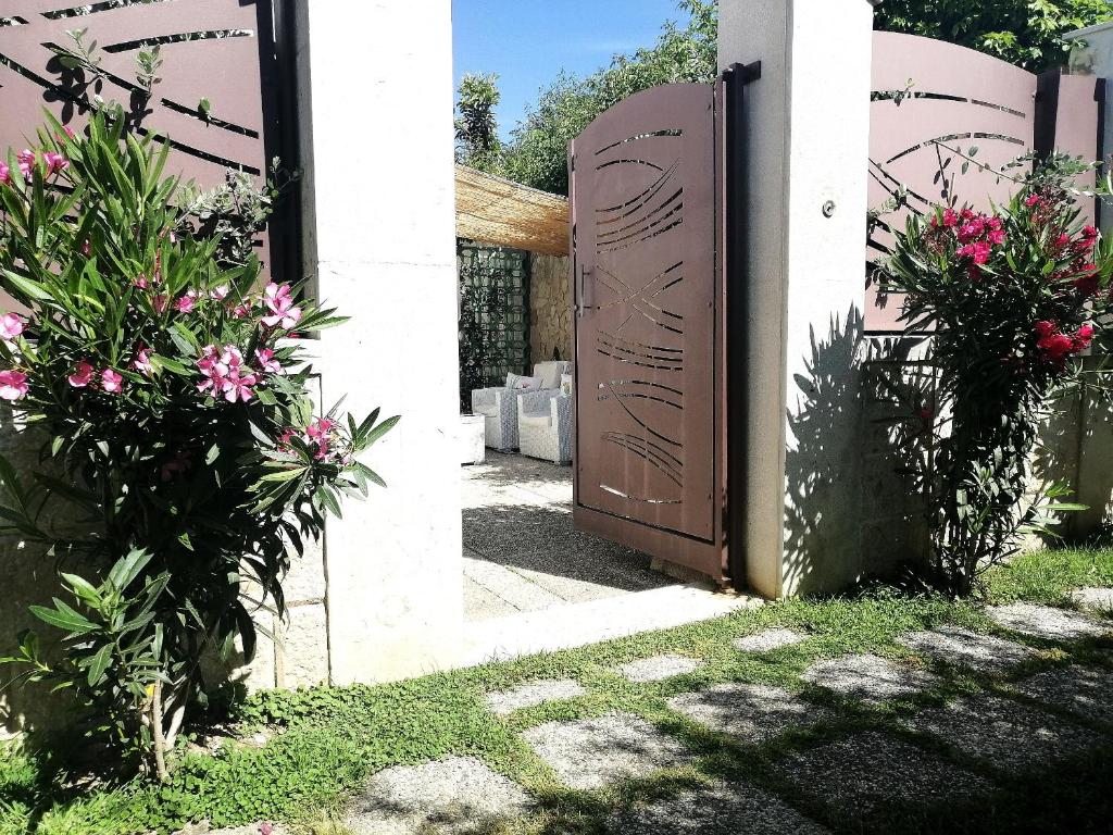un cancello in legno con fiori di fronte a una casa di DIMORA ARTEMISIO a Siponto