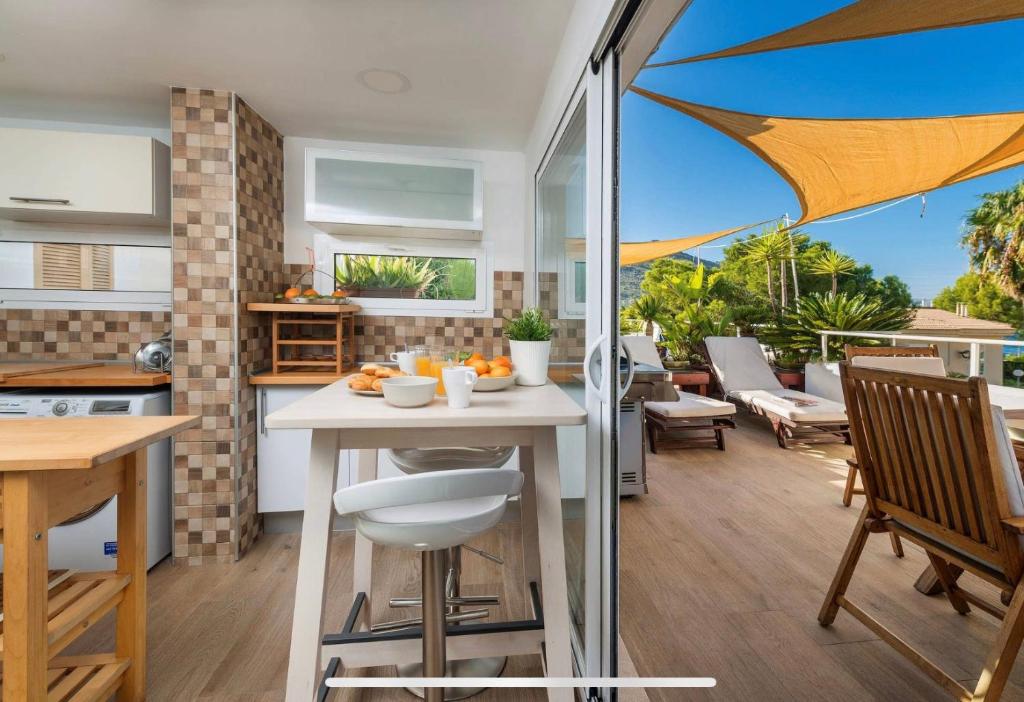 an open kitchen and dining room with an umbrella at Beach Inn Deluxe Apartment in Alcudia