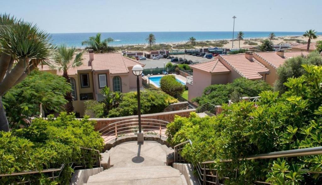 a house with a staircase leading to a beach at SANTA ANA 8 in Maspalomas