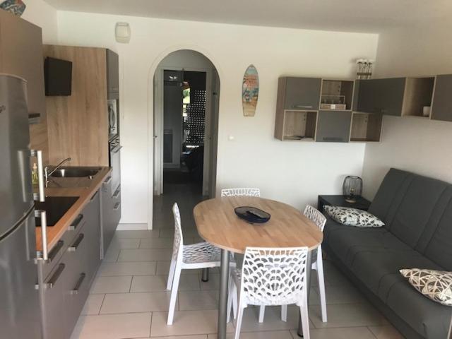 Una cocina y una sala de estar con una mesa y un sofá. en Marinas et mer 25, en Saint-Cyprien