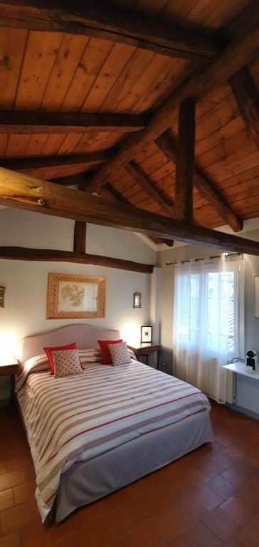 a bedroom with a large bed with a wooden ceiling at Altana Sul Tetto in Bologna