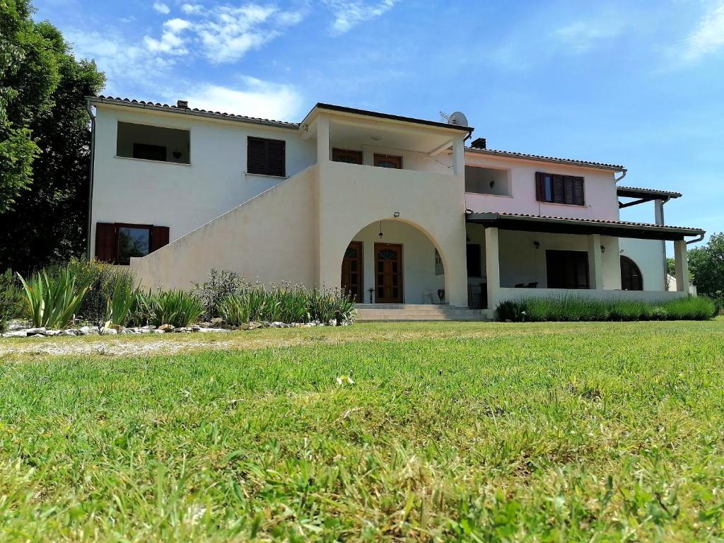 a large house with a grass field in front of it at Casa Val Madorso in Peroj