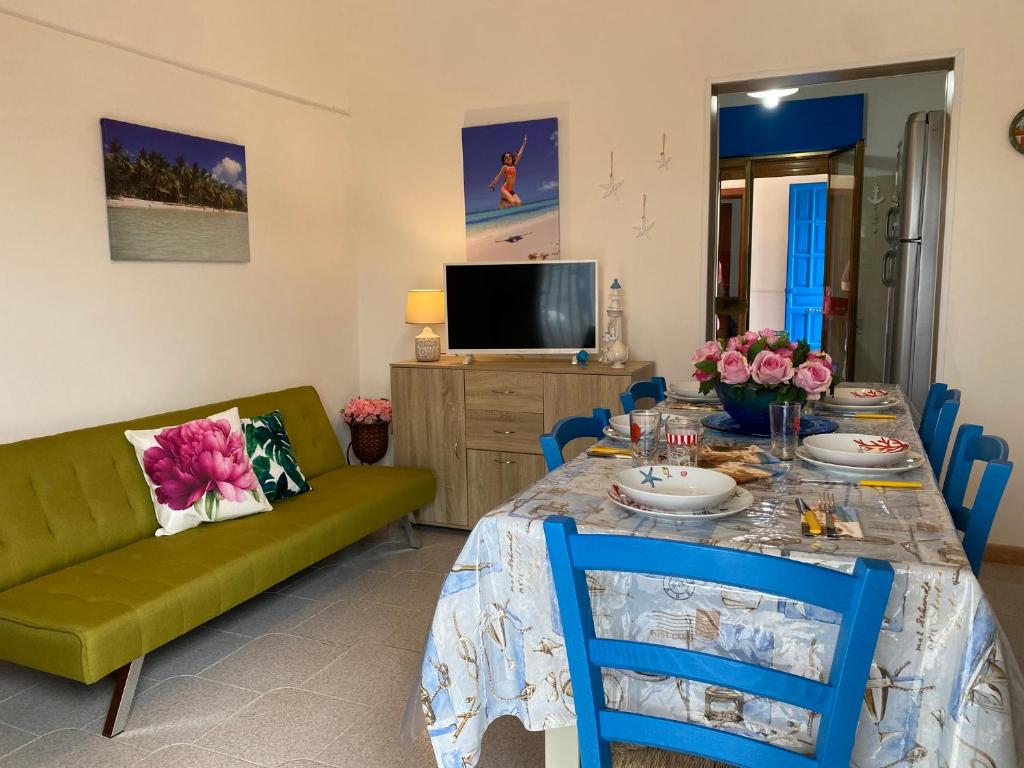 un soggiorno con tavolo e divano verde di Villa Antonietta By Cala Salento a Punta Prosciutto