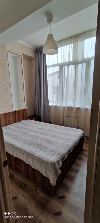ソチにあるApartments Vinogradnaya 188Aのベッドルーム1室(窓の前に大型ベッド1台付)