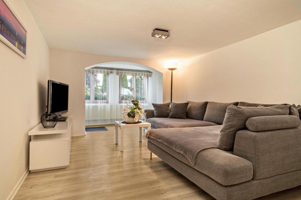 - un salon avec un canapé et une télévision dans l'établissement Gästehaus Heilig Ferienwohnung, à Langenargen