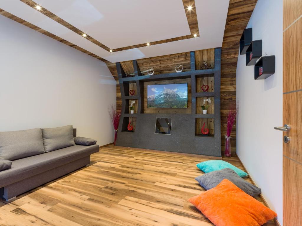 sala de estar con sofá y suelo de madera en Appartement Bergblick, en Ellmau