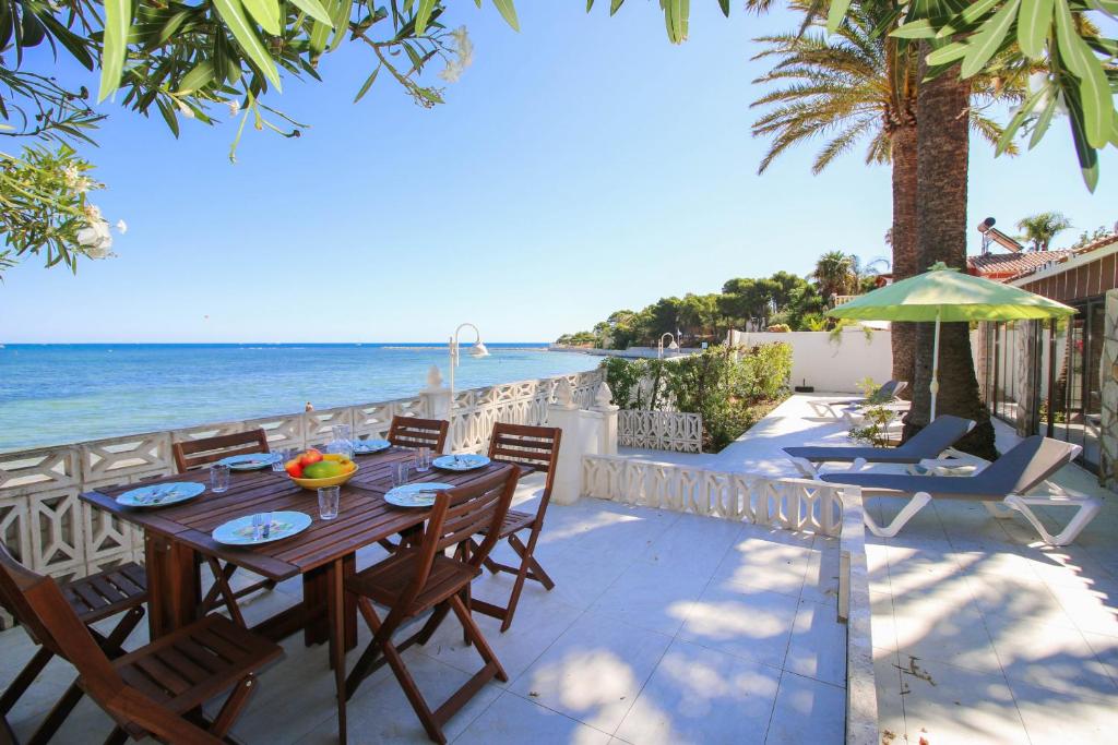 - une table et des chaises sur une terrasse donnant sur la plage dans l'établissement Las Rotas EA, à Dénia