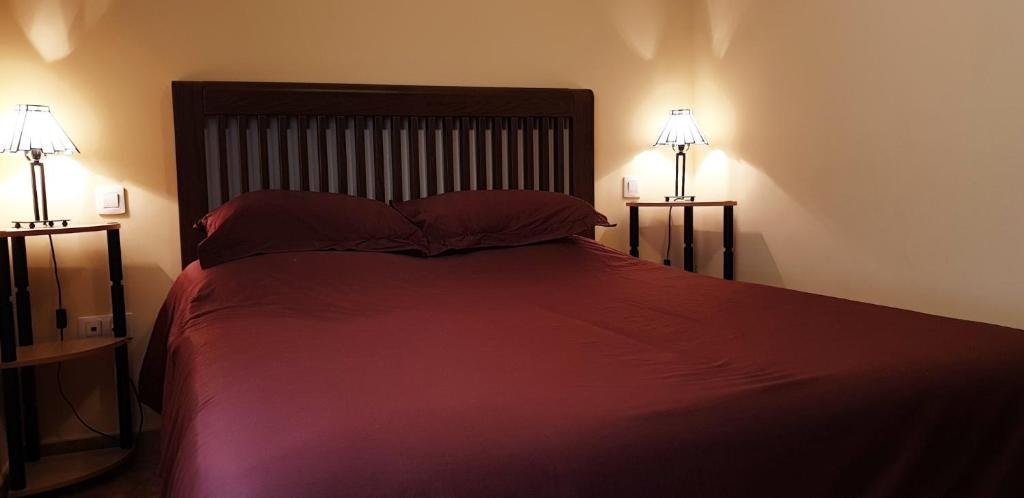 a bedroom with a large bed with two lamps at Villa Ghìo in Caleta De Fuste