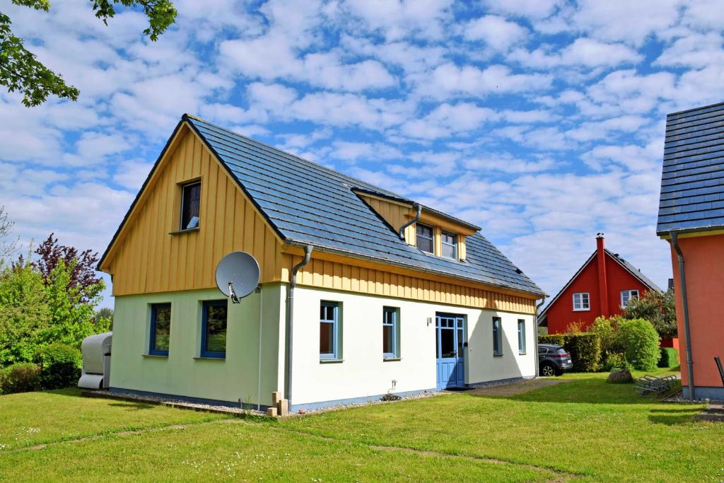 uma pequena casa branca com um telhado de gambrel em Ferienappartements Ostsee_ Nixen_ em Lobbe