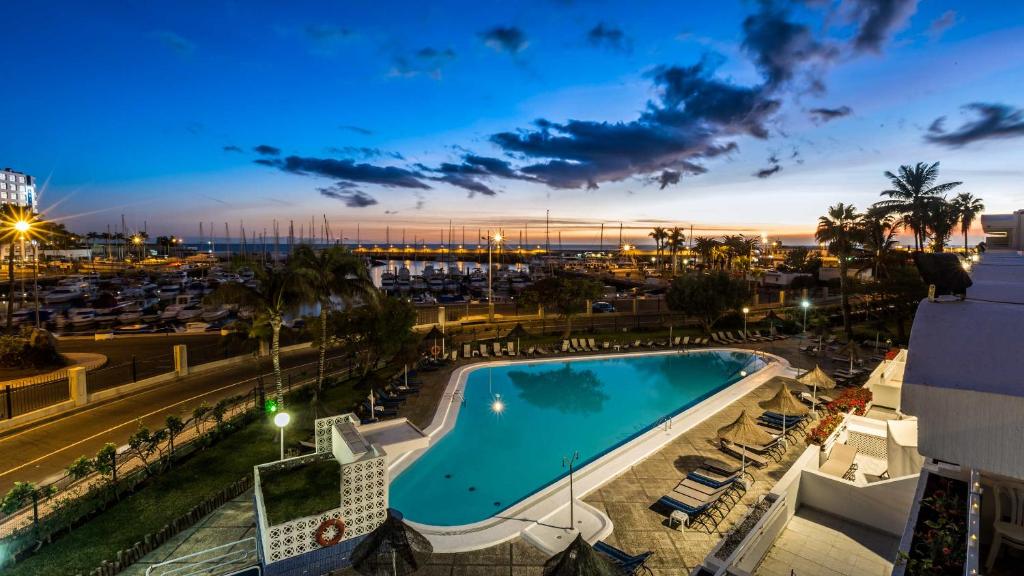 vista sulla piscina di notte di Apartamentos Portonovo a Puerto Rico de Gran Canaria