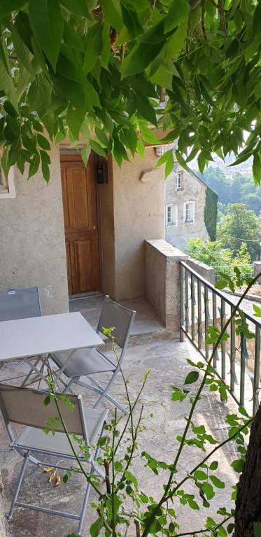 d'une table et de chaises sur un balcon avec porte. dans l'établissement Appartement de charme vieille ville, à Corte