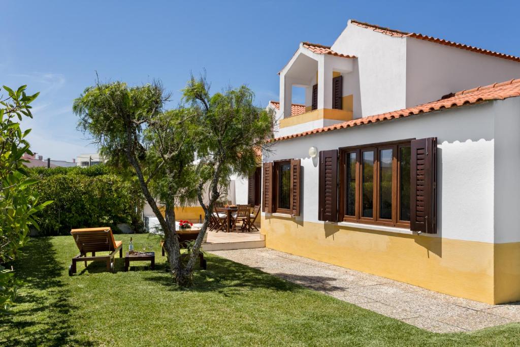 una casa con patio con mesa y sillas en ALTIDO 3-BR Cottage with Terrace and Garden in Colares en Sintra