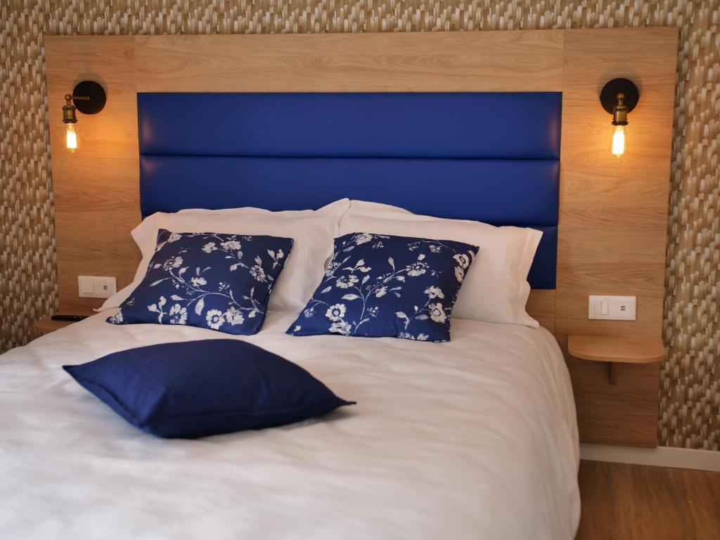 a bed with a blue head board and pillows at Plage à 50m Appartement Rêves bleus Villa Les Bains de Mers in Mers-les-Bains