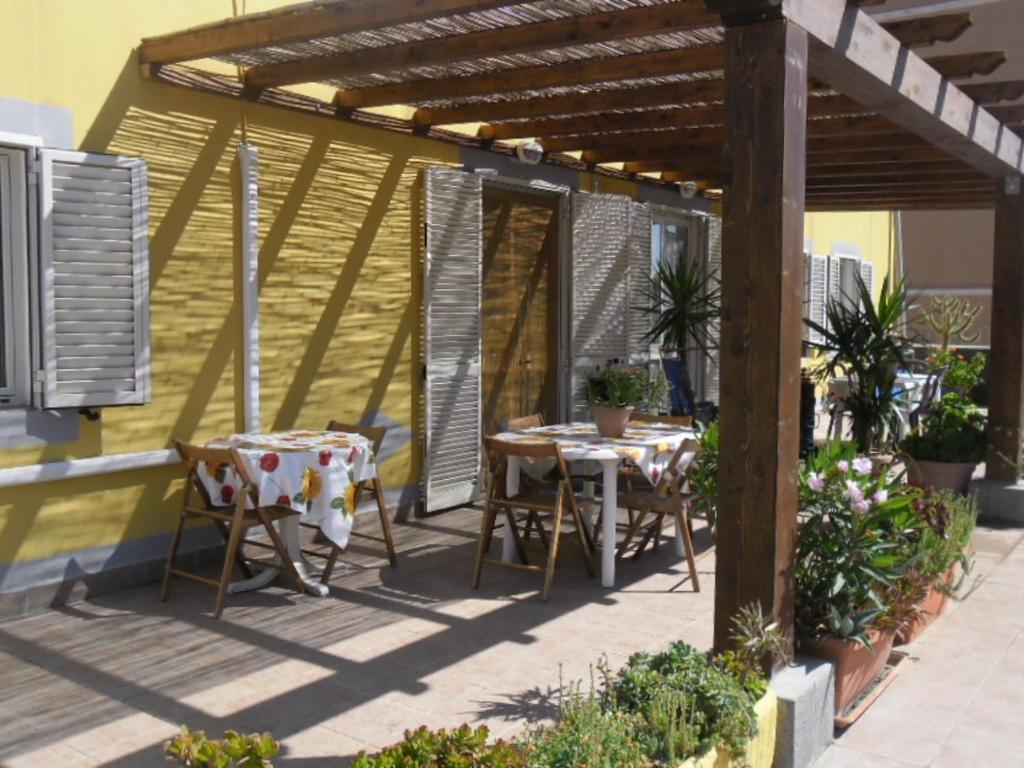 a patio with two tables and chairs under a pergola at Appartamenti Claudia Rio in Rio Marina