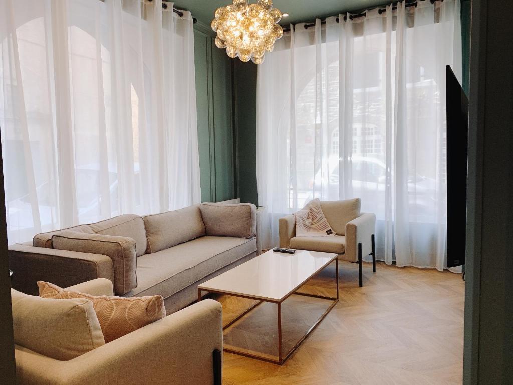 sala de estar con sofá, sillas y lámpara de araña en Appartement l'émeraude à Saint Malo Intra-Muros, en Saint-Malo