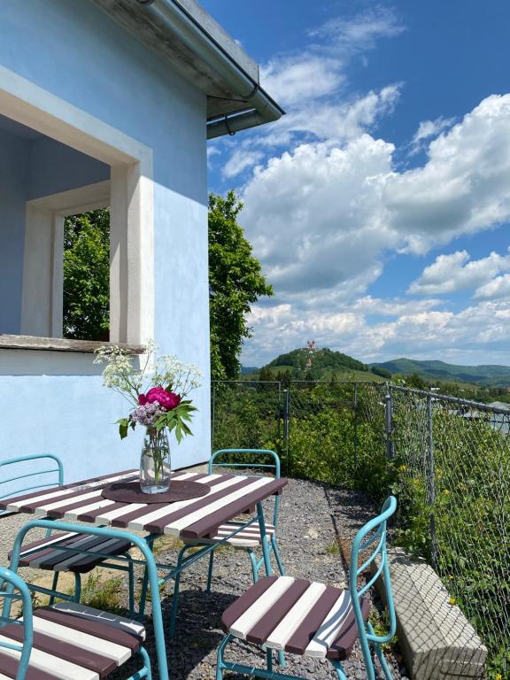 einen Terrassentisch mit Stühlen und eine Vase aus Blumen in der Unterkunft Dom s výhľadom in Banská Štiavnica