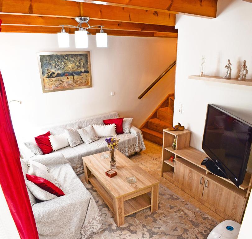a living room with a couch and a tv at Marilou's Cottage in Ágios Matthaíos