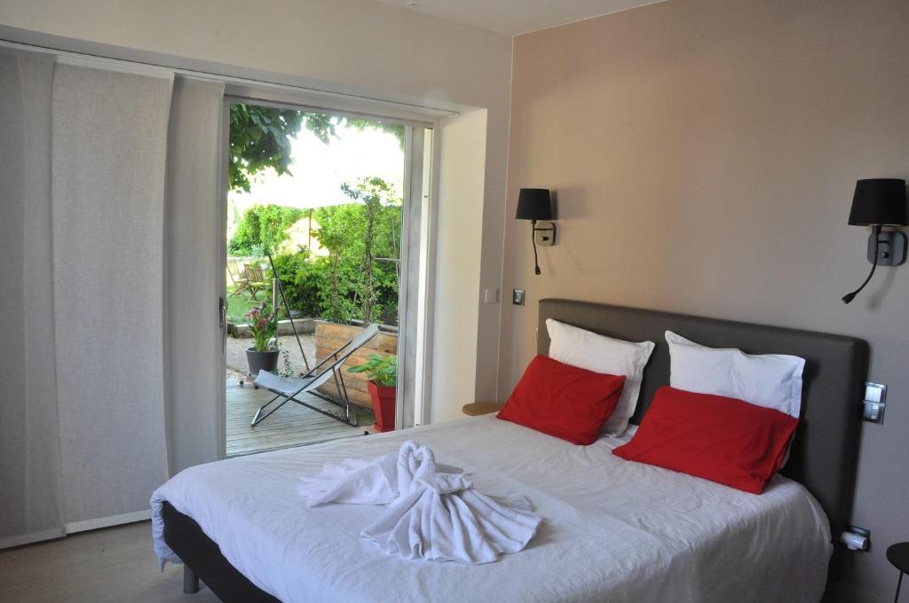 a bedroom with a bed with red pillows and a window at Le 505 in Saint-Jean-dÊ¼Avelanne