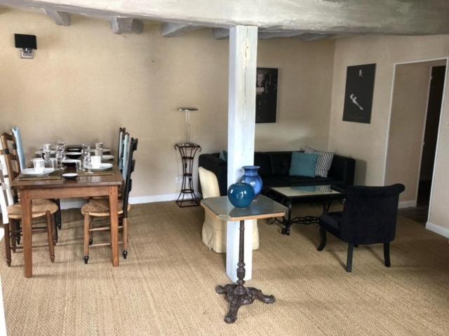 - un salon avec une table et une salle à manger dans l'établissement La Closerie - trois chambres, à Vicq-sur-Gartempe