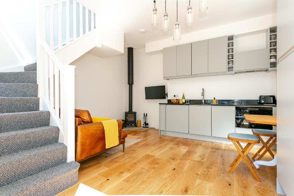 The Bs Hive, Modern, stylish, 2 bedroom house, in Harrogate centre في هاروغايت: غرفة معيشة بها درج ومطبخ